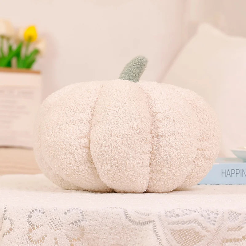 A fluffy, cream-colored 3D pumpkin shaped throw pillow for autumn decor resting on a white lace cloth.