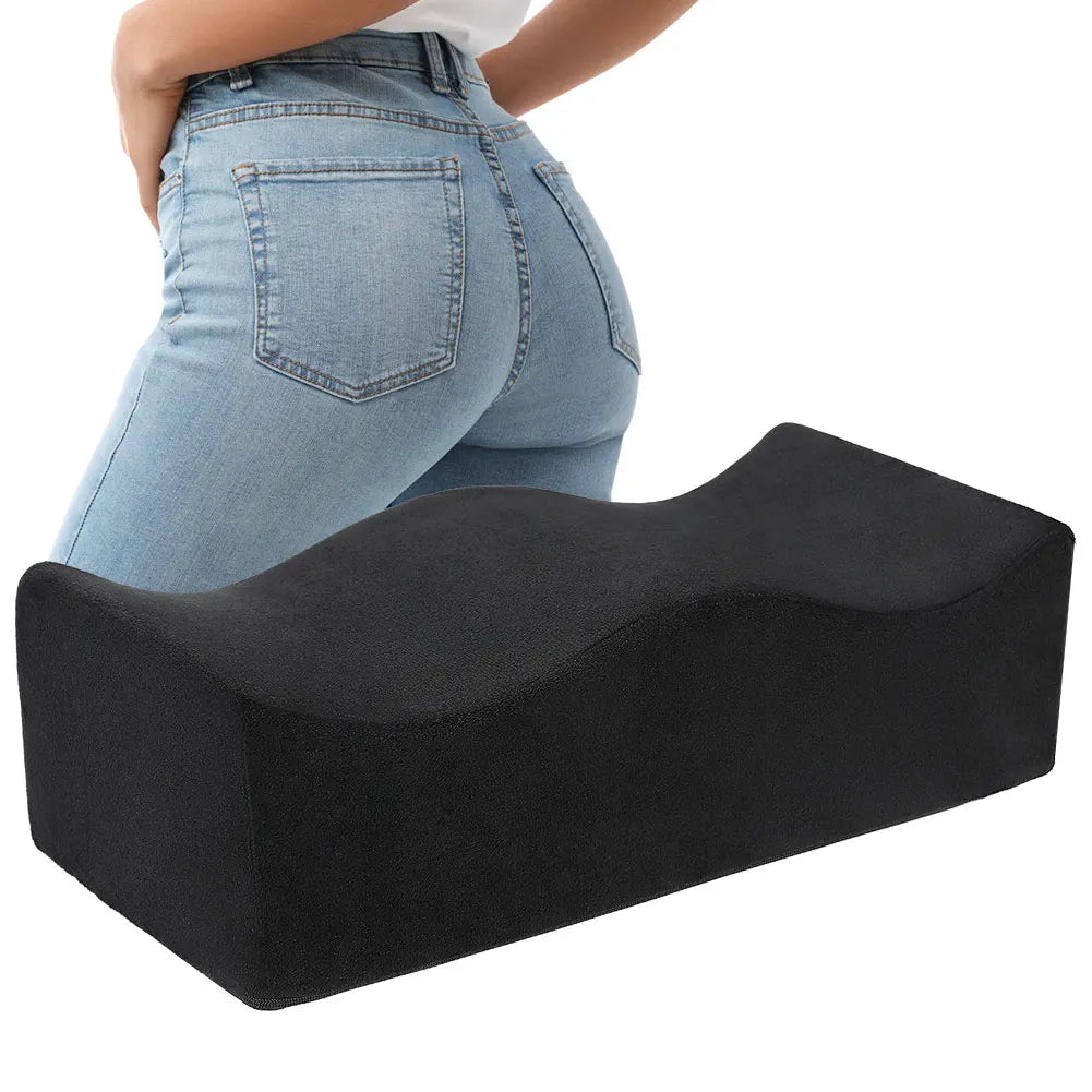 A person is shown wearing a black ergonomic seat cushion for tailbone relief and hip support.