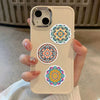 A hand holds a beige smartphone displaying colorful mandala graffiti stickers on the back.