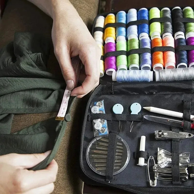 A hand is shown holding a black sewing kit containing various threads, needles, and tools for crafting.