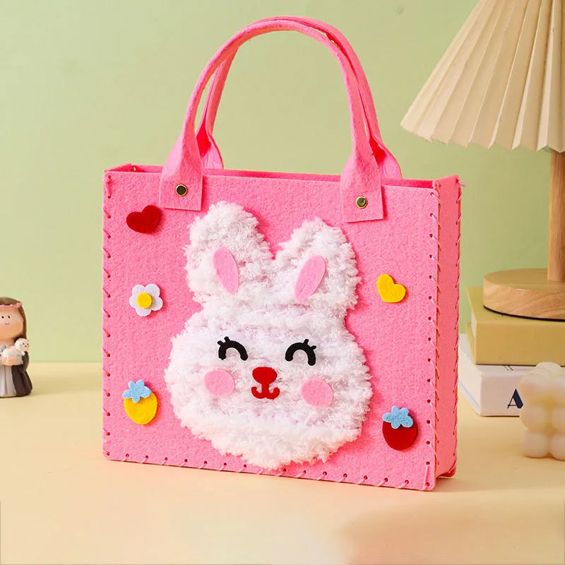 A pink felt bag with a white rabbit face design and pink handles.