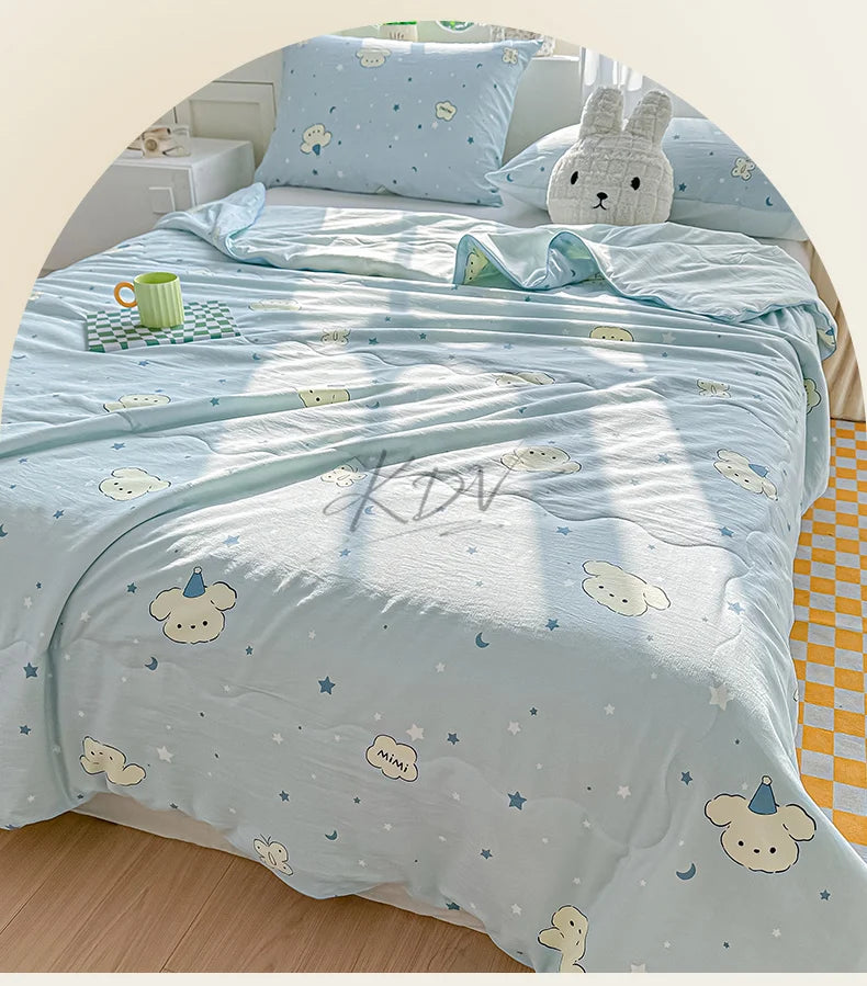 Light blue quilt blanket with a pastoral print featuring clouds, stars, and cute animal motifs on a bed.