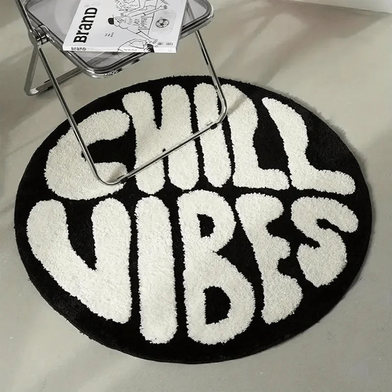 A round black rug with white text that reads CHILL VIBES is displayed under a metal stand.