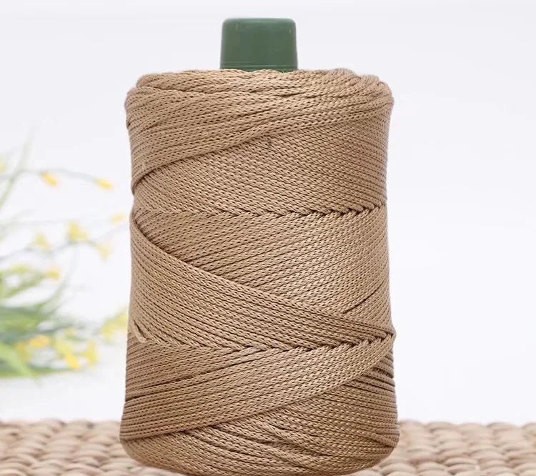A spool of tan crochet ice rope with a dark green cap resting on a woven mat.