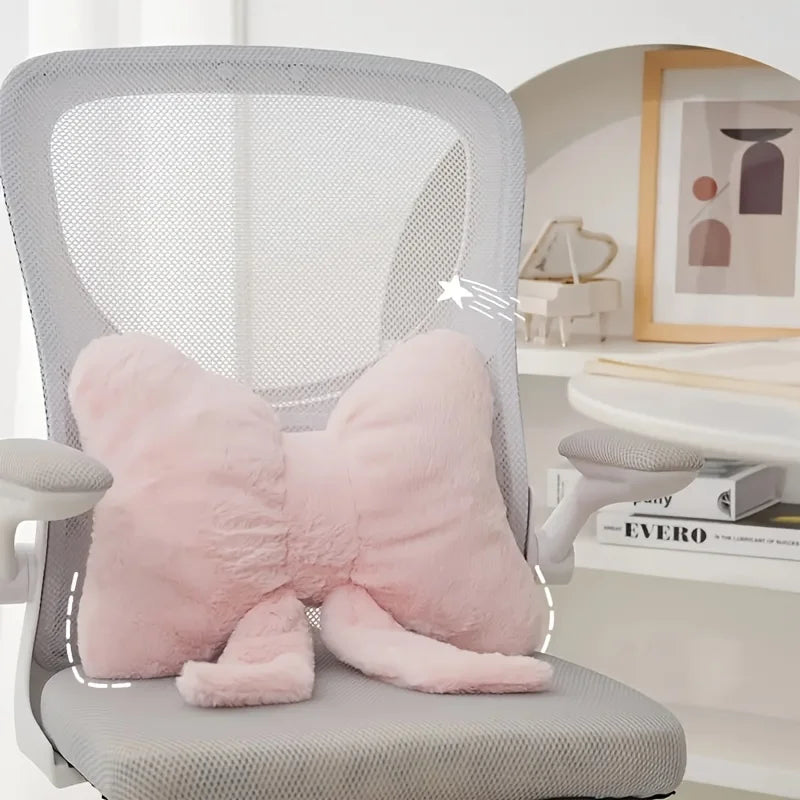 A pink decorative bow pillow resting on a gray chair with a mesh back.