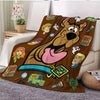 A brown cartoon dog design printed on a flannel throw blanket with various character illustrations.