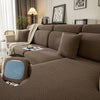 A brown plush elastic sofa cushion cover displayed on a sofa with neutral decor and lighting.