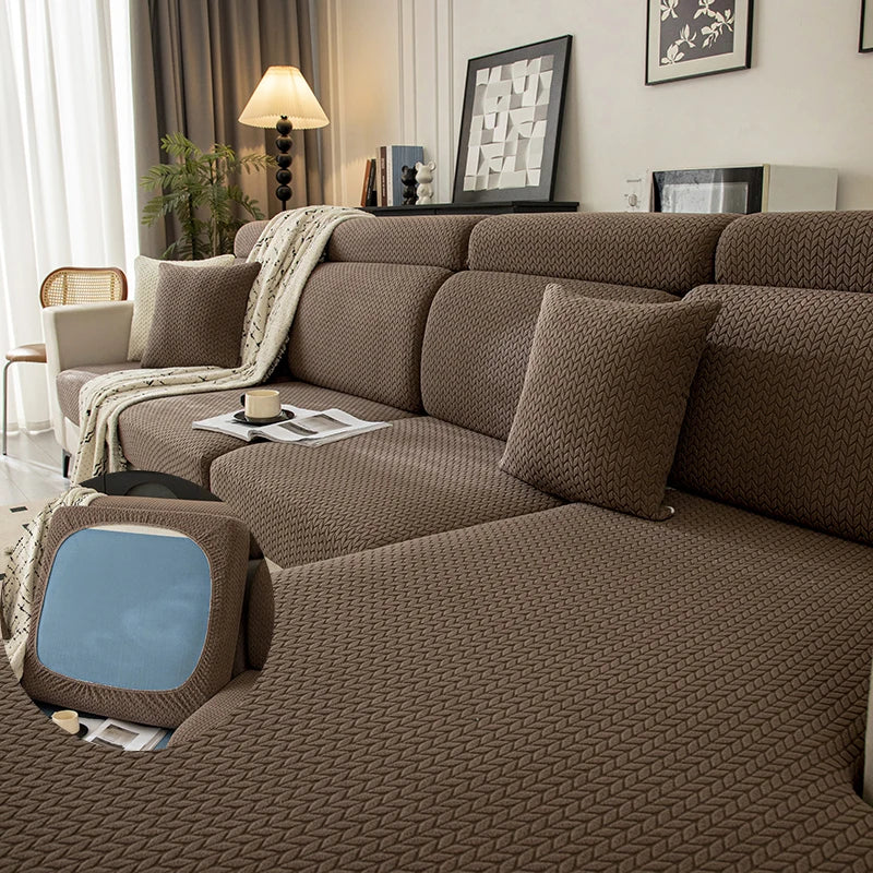 A brown plush elastic sofa cushion cover displayed on a sofa with neutral decor and lighting.