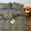 A plaid duvet cover set in olive green and beige tones with a grid pattern displayed on a bed.