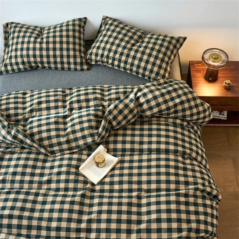 A plaid duvet cover set in olive green and beige tones with a grid pattern displayed on a bed.