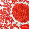 A pile of bright red resin sewing buttons scattered on a white surface.
