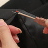A hand is using a stainless steel sewing needle to stitch fabric, showing the tip and a red thread on black cloth.