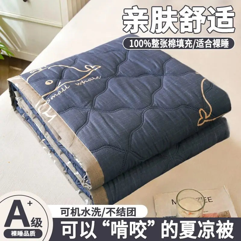 A navy blue quilted blanket or quilt with gold embroidery, folded on a white surface.