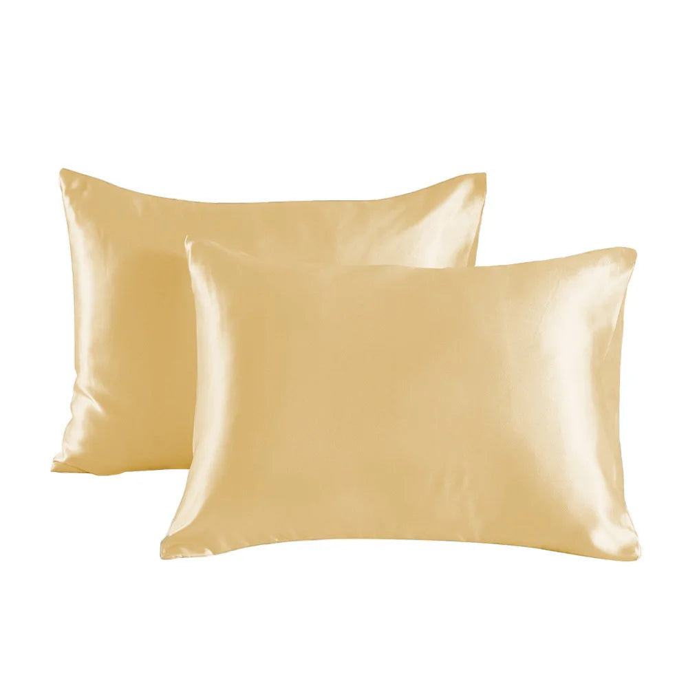 Two smooth satin pillowcases in a golden beige color are displayed against a white background.