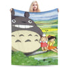 A fleece throw blanket featuring the Totoro character in a grassy outdoor setting.