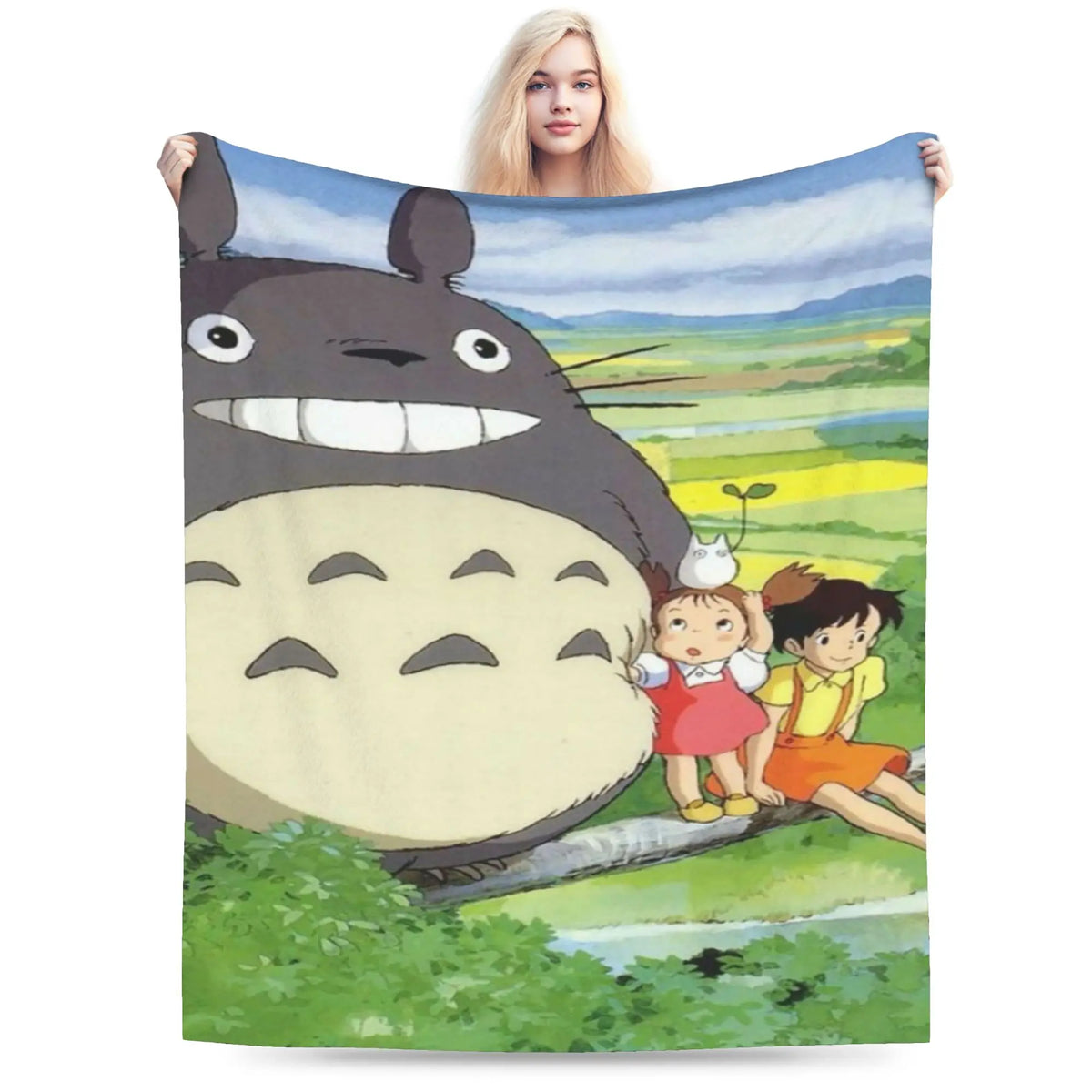 A fleece throw blanket featuring the Totoro character in a grassy outdoor setting.