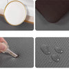A set of anti-fatigue PVC kitchen mats showing a white plate and several dark gray mats.