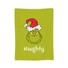 A lime green throw blanket featuring a cartoon monster wearing a red Santa hat and the word Naughty.