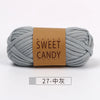 A skein of gray hand-dyed fabric strip yarn labeled Sweet Candy yarns.