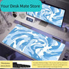 A blue and white swirling vortex mouse pad displayed on a desk next to a computer monitor.
