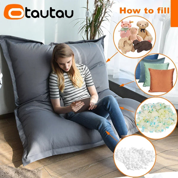 A woman is sitting on a gray outdoor bean bag cover, demonstrating how to fill the product with foam pellets.