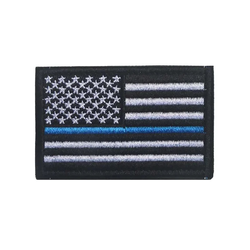 A black flag patch featuring the design of the American flag with white stars and horizontal stripes.