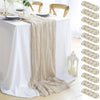 A cream colored semi-sheer gauze table runner draped over a white tablecloth.
