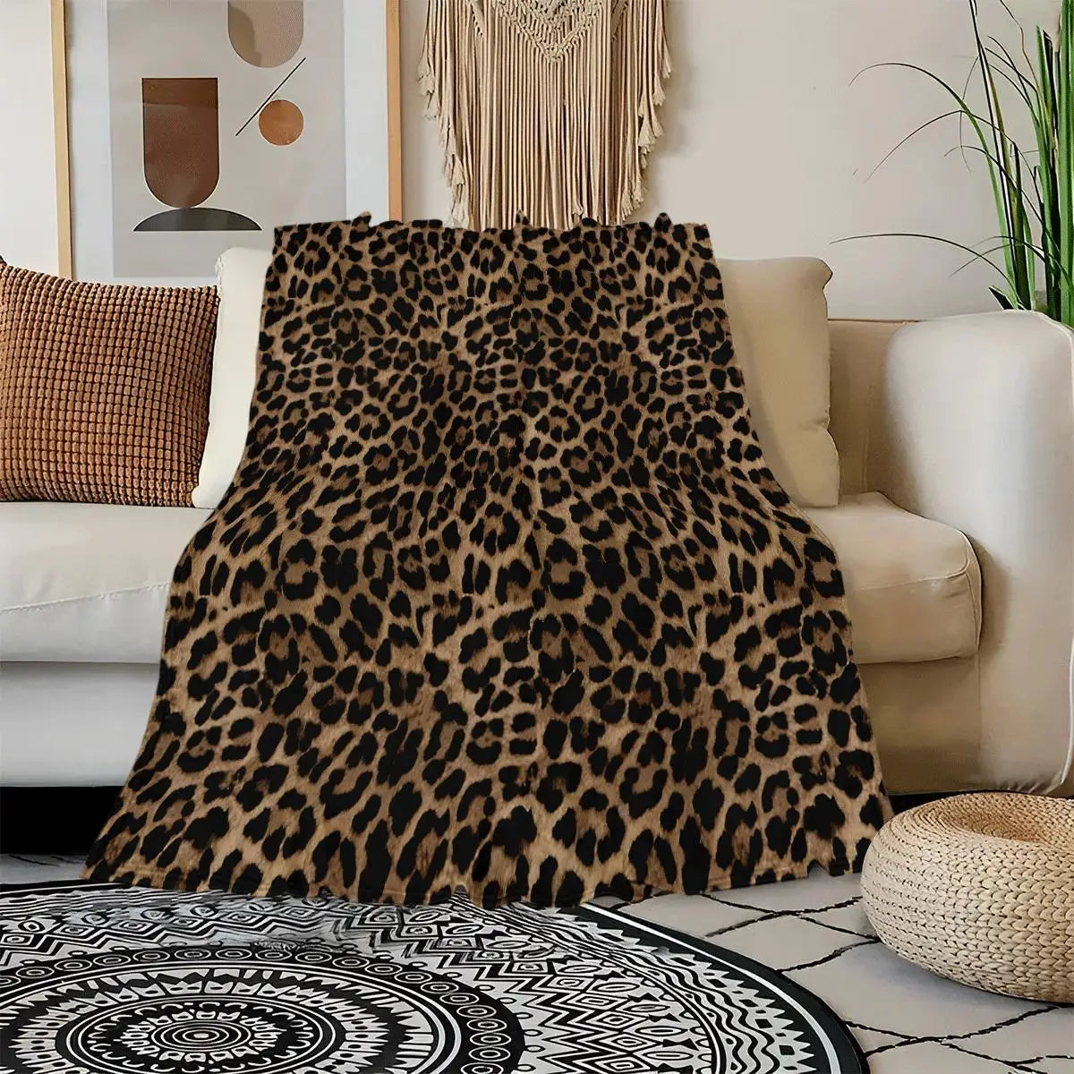 A luxurious leopard print flannel blanket draped over a sofa next to a woven rug.