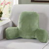 A plush, olive green lumbar support cushion with arms resting on a light gray sofa.