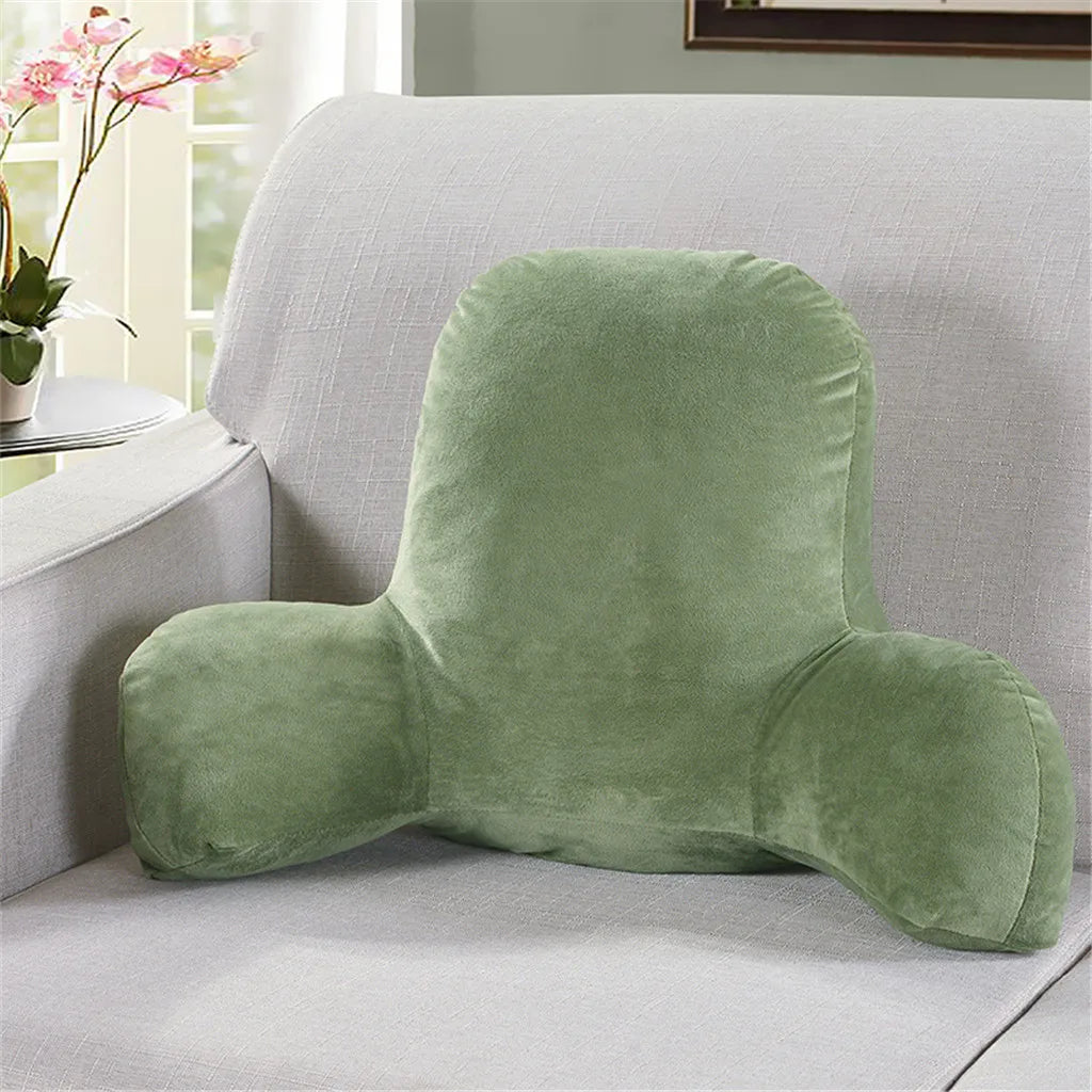 A plush, olive green lumbar support cushion with arms resting on a light gray sofa.