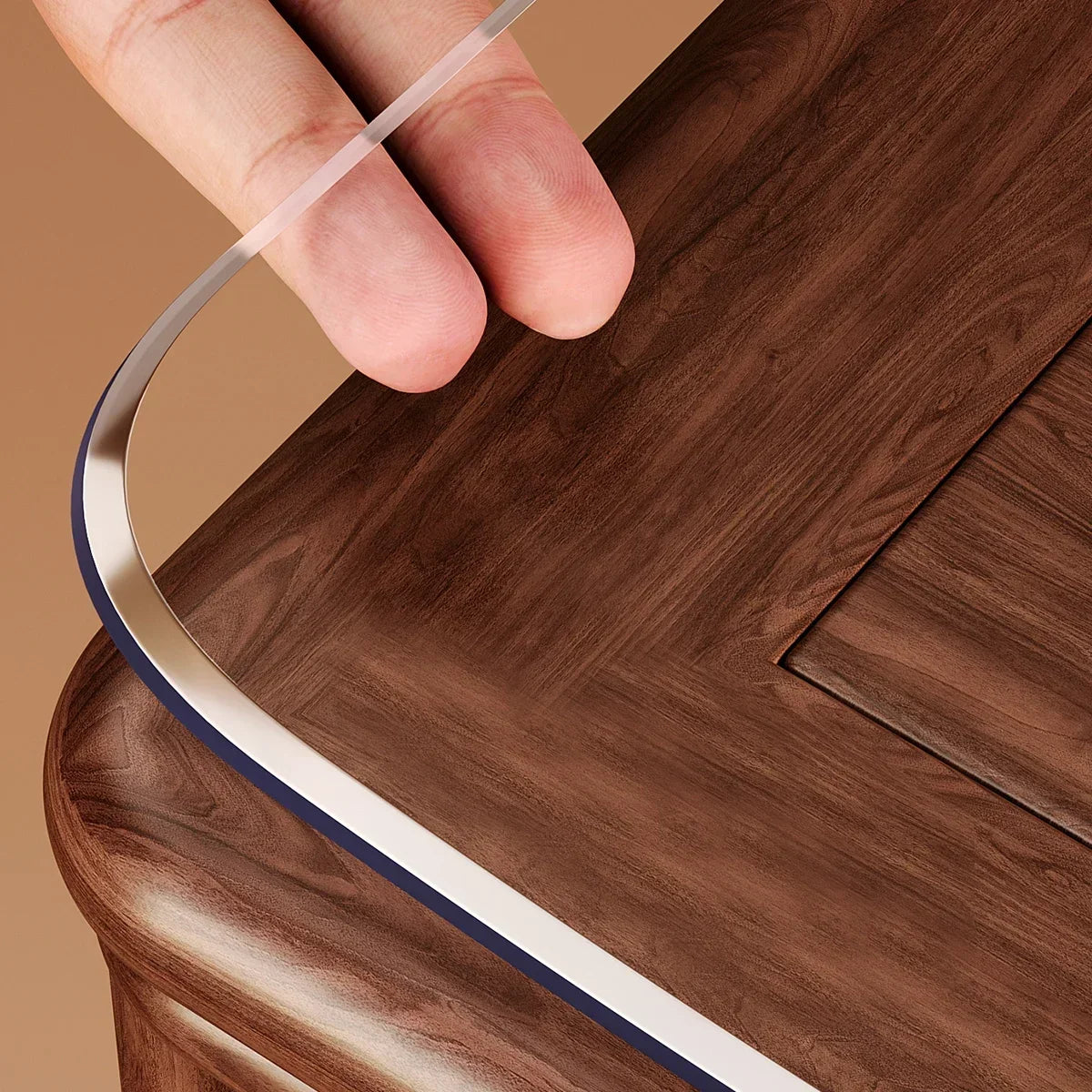 A hand is holding a clear PVC table protector mat with a dark brown border over a wooden surface.