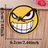 A yellow embroidered patch depicting a fierce, angry face with wide open teeth and furrowed brows.