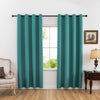 A pair of teal blackout curtains hanging in a window frame with a wooden dresser and chair nearby.