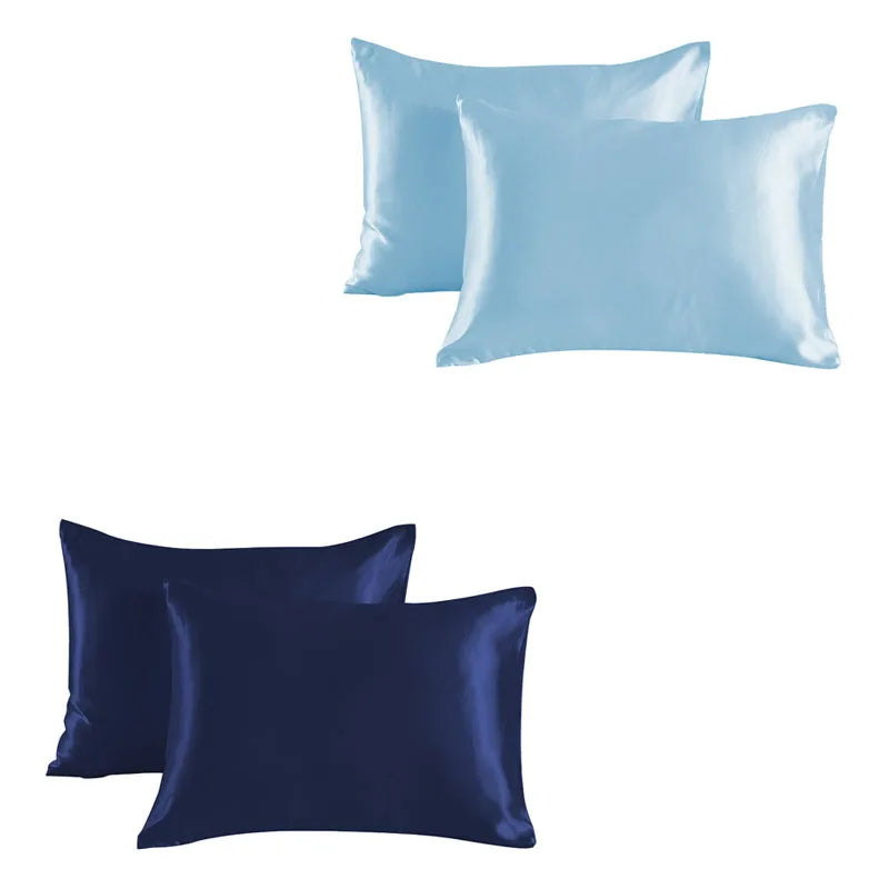 A set of two satin silk pillowcases, one light blue and one dark navy blue.