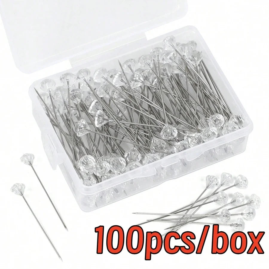 A box containing 100 clear diamond pins or needles for crafting and decoration.