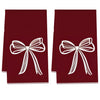 A set of two deep red kitchen towels featuring white bow designs.
