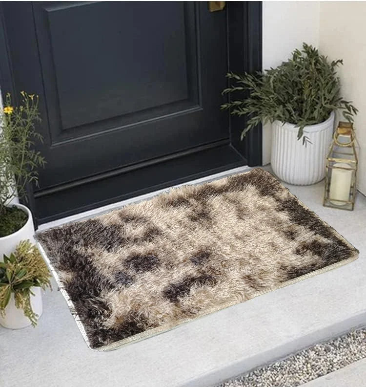 A rectangular faux fur area rug with brown and black mottled patterns placed on a light gray floor.