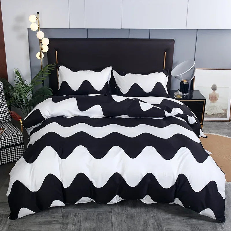 A black and white geometric duvet cover set displayed on a bed with a dark headboard.