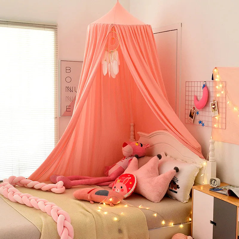 A pink princess hanging bed canopy decorated with pink fabric and plush toys in a bedroom setting.