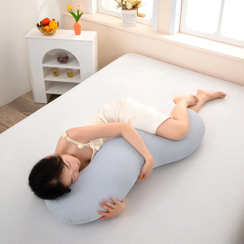 A person is lying down and using a light blue ergonomic double wave curve pillow for support.