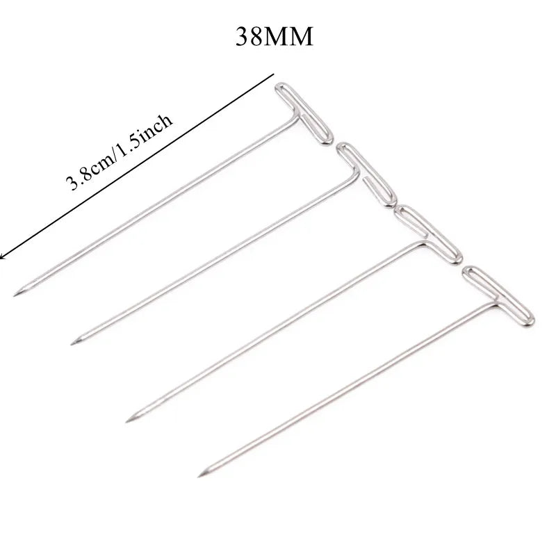 A set of stainless steel T-pins for wig making or knitting, showing various sizes and a measurement scale.