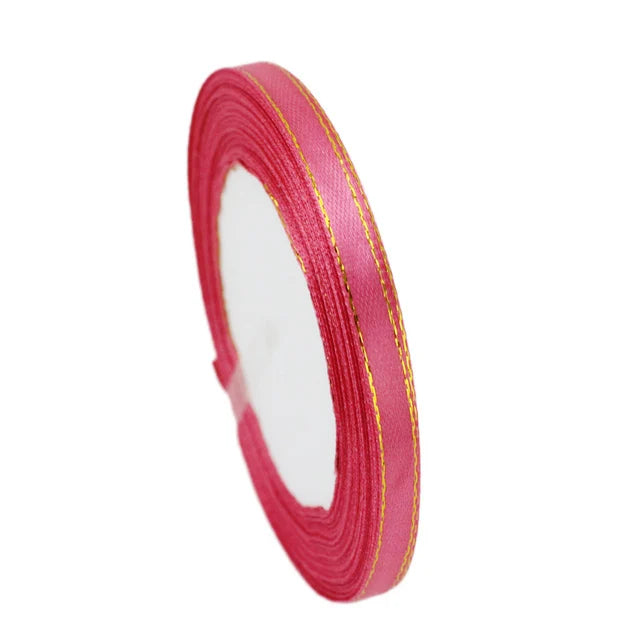 Roll of 6mm gold-edged satin ribbon in pink for gift wrapping and crafts