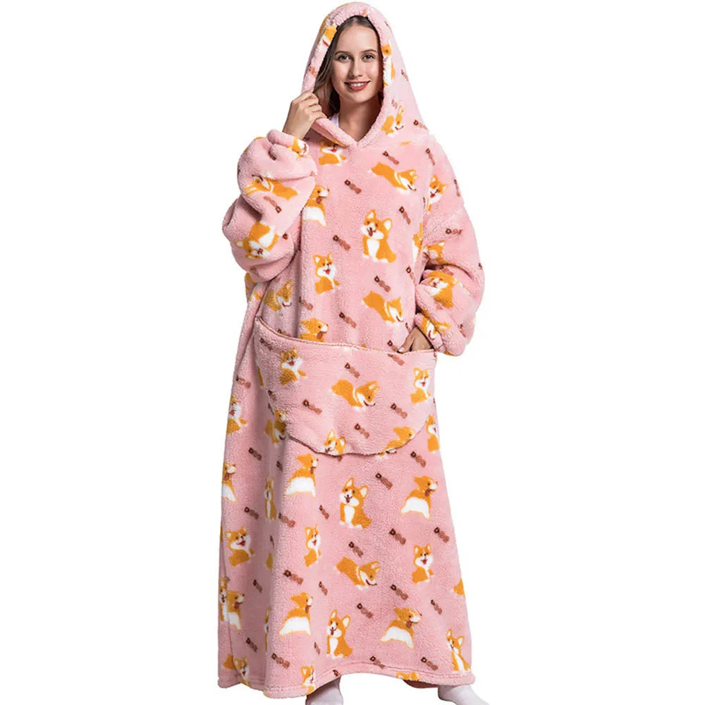 A woman wearing a pink sherpa fleece oversized blanket hoodie with a dog print pattern.