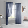A pair of long, blue sheer curtains with rod pockets hanging in a window frame.