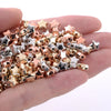 A handful of mixed gold silver and rose gold star-shaped acrylic beads for jewelry making