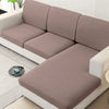 A modern, light beige sofa with a slipcover featuring soft cushions and white trim in a bright room.