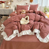 A plaid duvet cover set featuring red and white checks with lace embroidery, displayed on a bed.