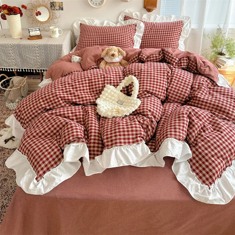A plaid duvet cover set featuring red and white checks with lace embroidery, displayed on a bed.