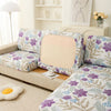 Floral print elastic sofa protective cover featuring purple and green botanical patterns.