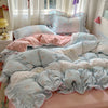 A floral bedding set featuring light blue and pink patterned sheets and pillows on a bed.